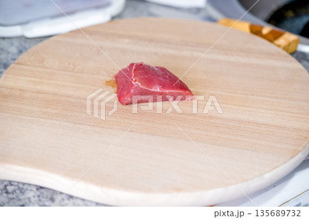 Fresh meat on a wooden board with a knife 135689732