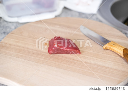 Fresh meat on a wooden board with a knife 135689748