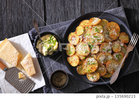 Roasted Potato Slices with Parmesan Cheese Top View Roasted Potato Slices with Parmesan Cheese Top View 135690213