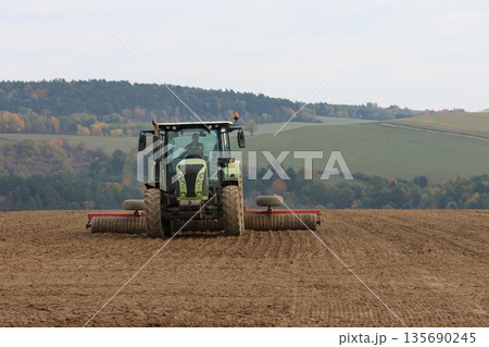 Tractor is cultivating the soil 135690245