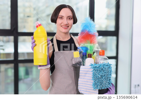 Bright and cheerful cleaning day with a dedicated professional holding vibrant supplies in a modern workspace Bright and cheerful cleaning day with a dedicated professional holding vibrant supplies in a modern workspace 135690614