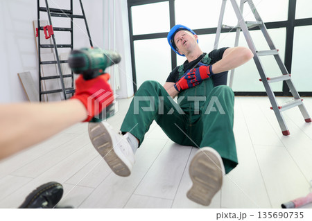 Worker experiences an unfortunate mishap while renovating an indoor space in a modern building setting 135690735