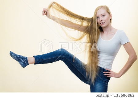 Blonde girl brushing her long hair 135690862