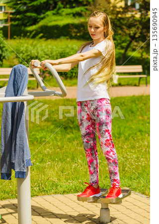 Female doing exercise in outdoor gym 135690945
