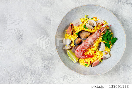 seafood paella, on a plate, traditional Spanish dish, top view, no people, 135691158