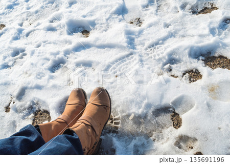 Somebody legs with warm winter shoes on snow 135691196