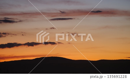 Sunset over hilly coastal land 135691228