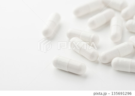 White pills on a white background 135691296