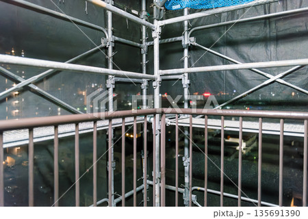 マンション外壁補修の足場 夜景が透けるメッシュシート 工事現場の背景素材 マンション外壁補修の足場 夜景が透けるメッシュシート 工事現場の背景素材 135691390