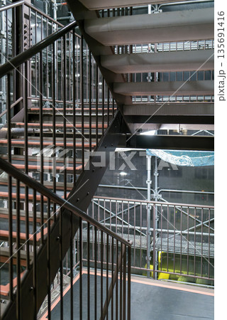 マンション改修工事の足場通路　安全ネットと鉄パイプ　工事背景 135691416