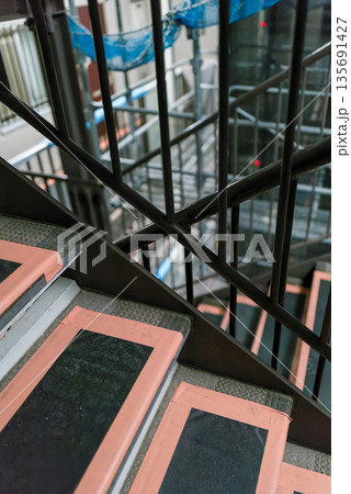 マンション改修工事の足場通路 安全ネットと鉄パイプ 工事背景 マンション改修工事の足場通路 安全ネットと鉄パイプ 工事背景 135691427