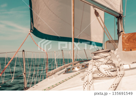 Yachting on sail boat during sunny weather Yachting on sail boat during sunny weather 135691549