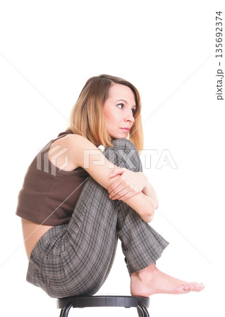 worried and afraid young woman sitting on chair. Isolated 135692374