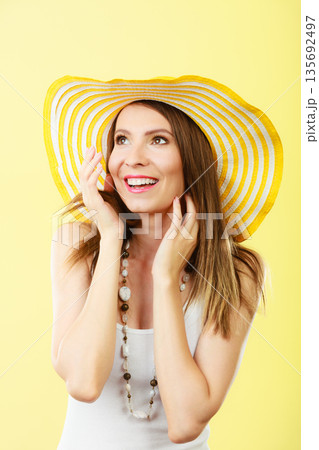 Woman in big yellow summer hat. Woman in big yellow summer hat. 135692497