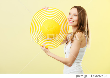 Woman in big yellow summer hat. Woman in big yellow summer hat. 135692498