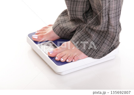 Woman feet and weight scale isolated on white background Woman feet and weight scale isolated on white background 135692807