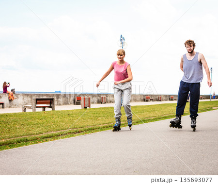 Active young people friends rollerskating outdoor. Active young people friends rollerskating outdoor. 135693077
