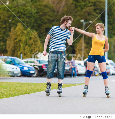 Young couple on roller skates riding outdoors 135693321