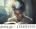 A girl is preparing for an exam and reading a book. 135693350