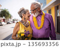 An elderly couple walks down the street and rejoices at their wedding 135693356