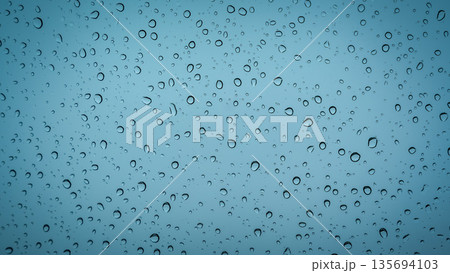 Water droplets on glass surface with soft blue background Water droplets on glass surface with soft blue background 135694103