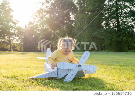 Pretend play child. Girl aviation pilot toy. Summer fun outdoor cardboard. 135694730