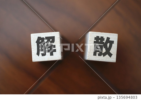 解散を象徴する木製ブロックと暗色の木目背景。 135694803