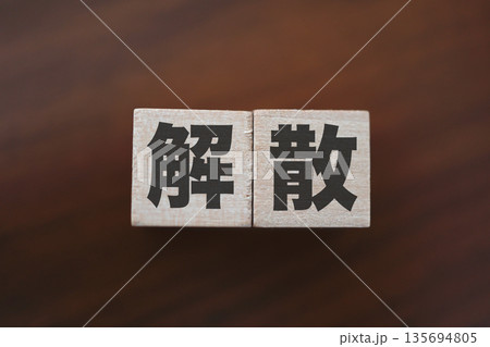 解散を象徴する木製ブロックと暗色の木目背景。 135694805