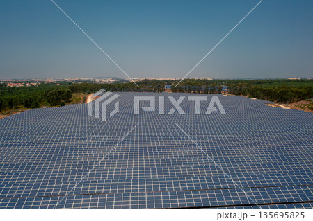 Solar power plant surrounded by green landscape 135695825