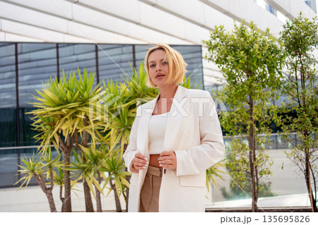 Confident businesswoman in blazer standing near 135695826