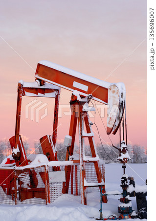 Snow Covered Oil Pumpjack at Winter Sunrise Snow Covered Oil Pumpjack at Winter Sunrise 135696007