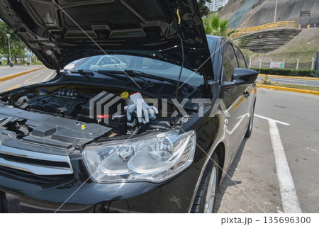 Car breakdown with hood open inspecting engine 135696300