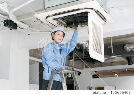 エアコンの点検をする女性作業員 135696468