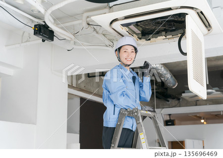 エアコンの点検をする女性作業員 135696469