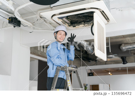 エアコンの点検をする女性作業員 エアコンの点検をする女性作業員 135696472