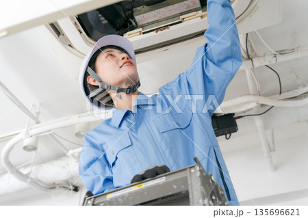 エアコンの点検をする女性作業員 135696621