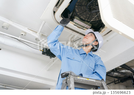 エアコンの点検をする女性作業員 135696623