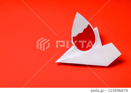 Paper drop shape with vibrant red color on a red surface Paper drop shape with vibrant red color on a red surface 135696679
