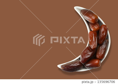 Dates placed in a crescent-shaped bowl for Ramadan festivity Dates placed in a crescent-shaped bowl for Ramadan festivity 135696706