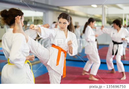 Women practice karate techniques in pairs Women practice karate techniques in pairs 135696750