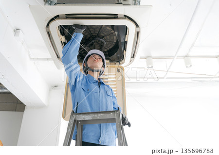 エアコンの点検をする女性作業員 エアコンの点検をする女性作業員 135696788