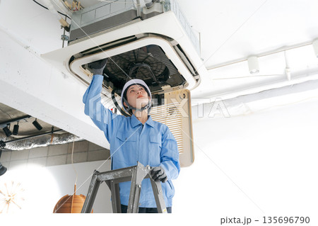 エアコンの点検をする女性作業員 エアコンの点検をする女性作業員 135696790
