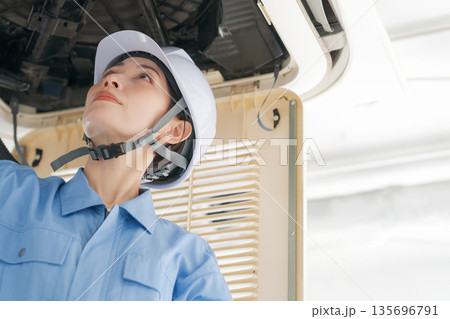 エアコンの点検をする女性作業員 エアコンの点検をする女性作業員 135696791