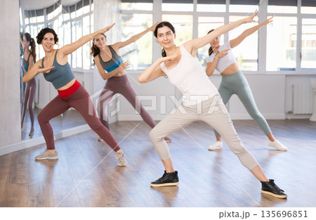 Young woman doing dabbing during street dance workout in studio 135696851