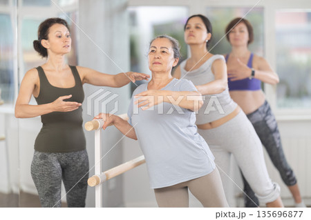 Senior woman practicing at amateur ballet class with female choreographer Senior woman practicing at amateur ballet class with female choreographer 135696877