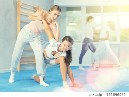 Two young women training self-defense techniques Two young women training self-defense techniques 135696933