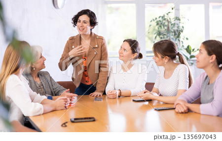 Hispanic woman holding meeting with group of fellow female students 135697043