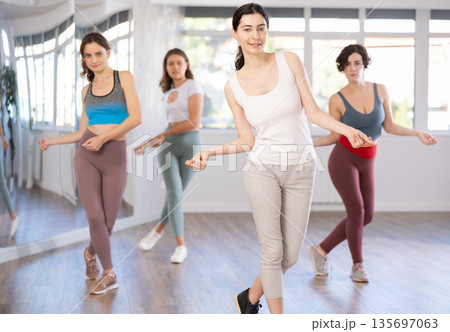 Young female teacher conducts modern hip hop dance lessons for group of girls Young female teacher conducts modern hip hop dance lessons for group of girls 135697063
