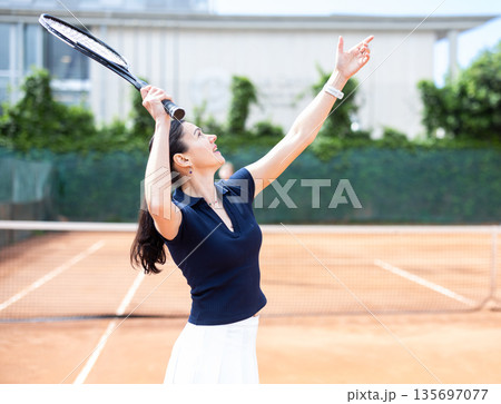Girl plays tennis on open court with opponent Girl plays tennis on open court with opponent 135697077