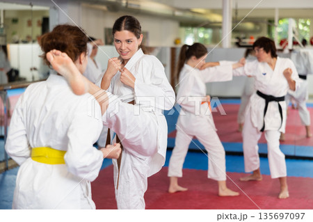 Women practice karate techniques in pairs Women practice karate techniques in pairs 135697097